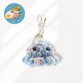 A crocheted octopus keychain charm in pastel blue, purple, and pink yarn with black bead eyes and a gold metal clasp.