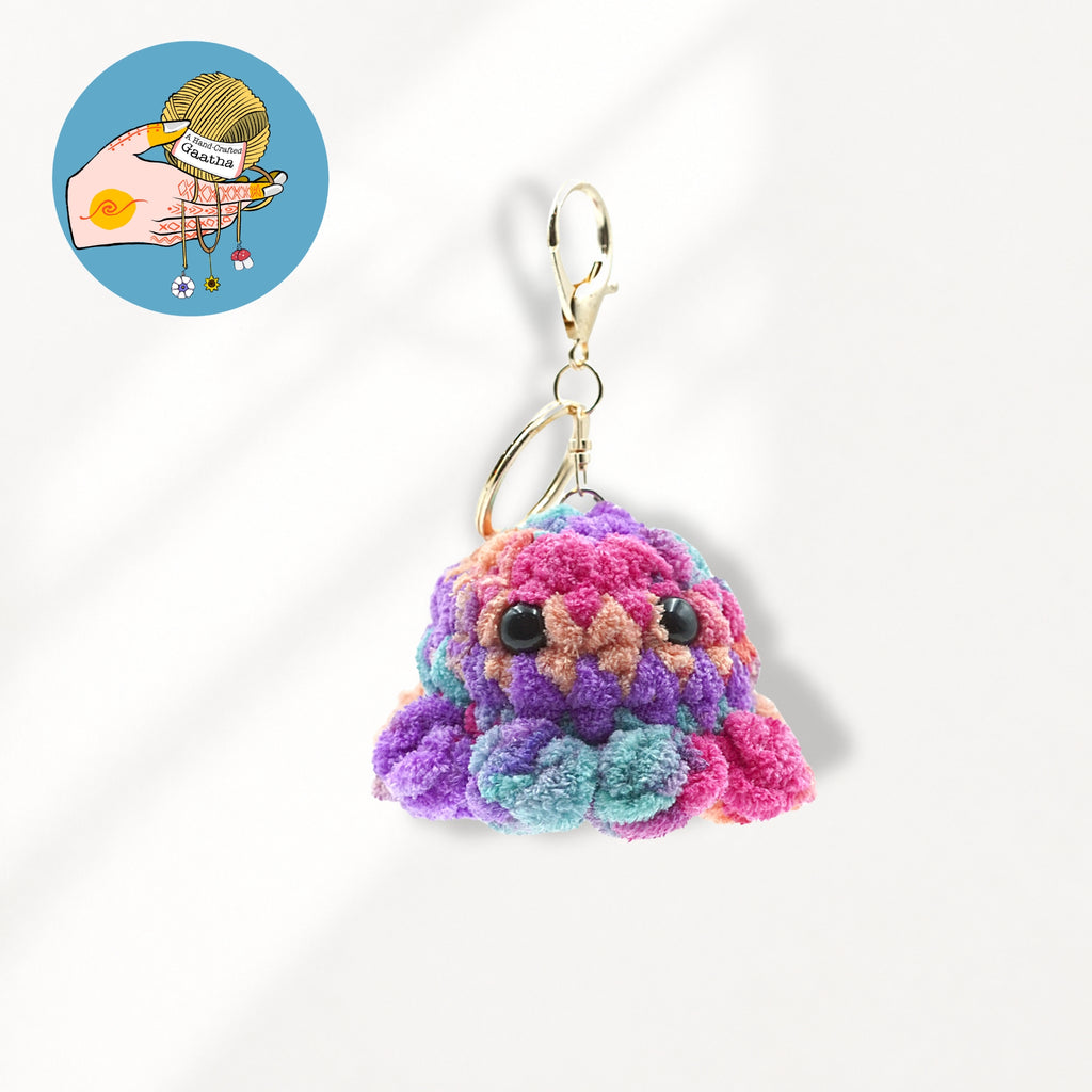 A colorful, fuzzy octopus-shaped keychain charm with black bead eyes and a gold-tone lobster clasp.