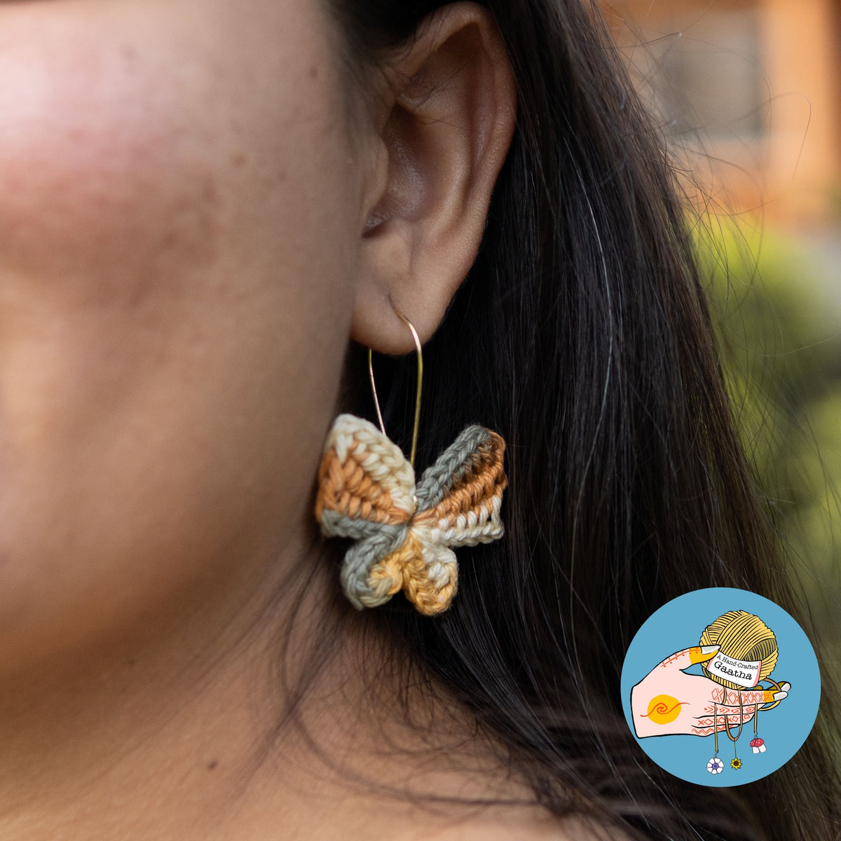 Model wearing handmade earthy crochet butterfly hoop earrings