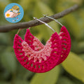 Vibrant pink and light pink ombré crochet hoop earrings featuring an intricate lace-like stitch, displayed on a tree branch.

