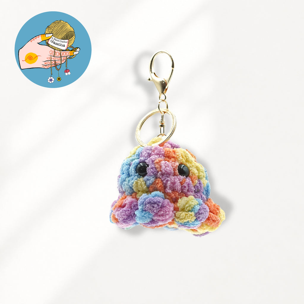 A colorful crocheted monster keychain charm with a gold lobster clasp.